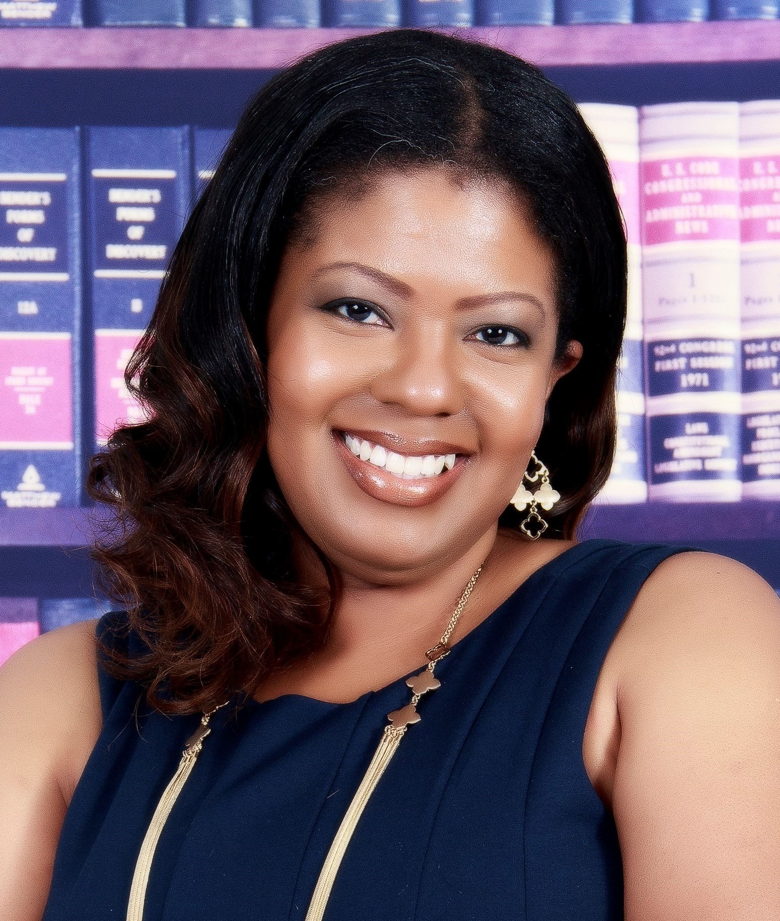 Headshot of a smiling woman in a blue dress.