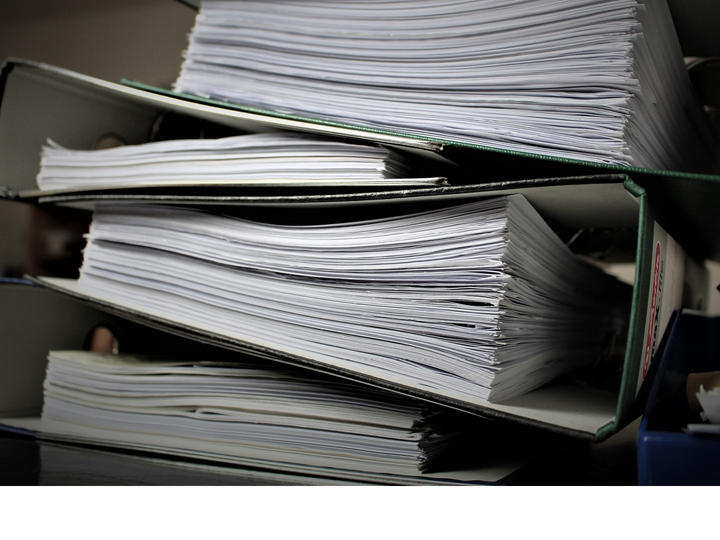 Stack of binders full of papers.