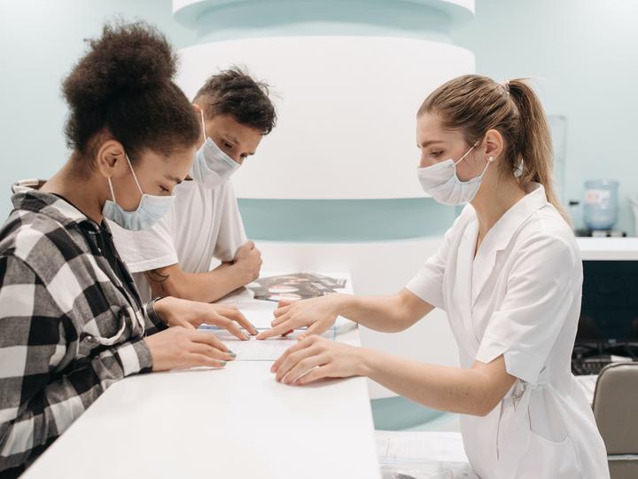 young couple in masks at doctor