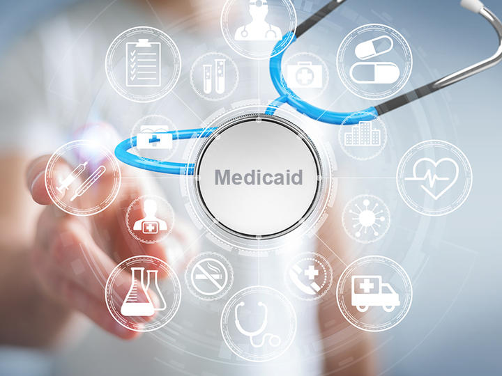 Digital image of doctor's stethoscope with "Medicaid" in center and person pointing towards the camera.