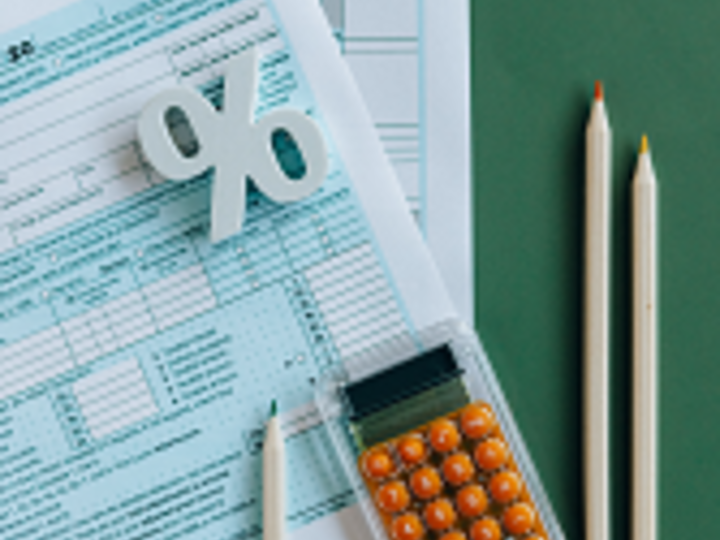 Paperwork, paper clips, pencils and calculator on green desk.