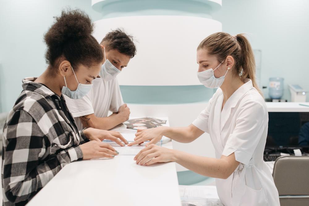 young couple in masks at doctor