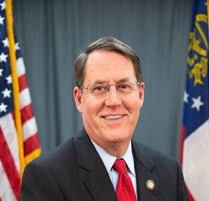 Dr. Dean Burke in front of flags.