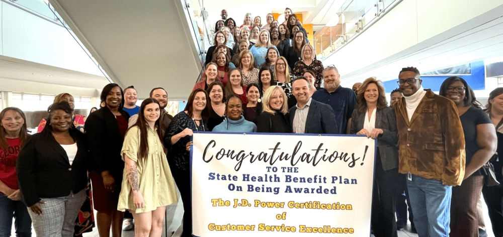 SHBP call center associates group photo holding congratulations banner