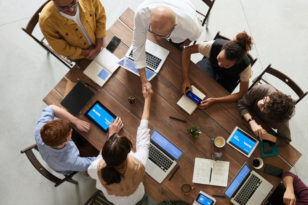 Photo of people shaking hands and working together at a table