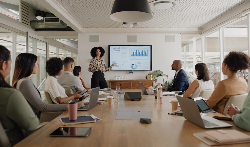 Women giving presentation to attendees in conference room