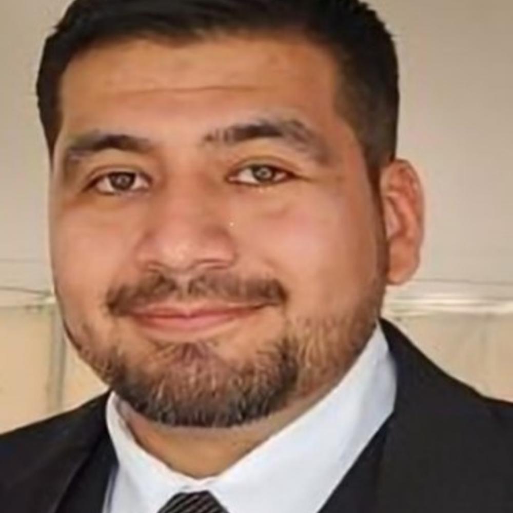 Headshot of male employee in front of tan background