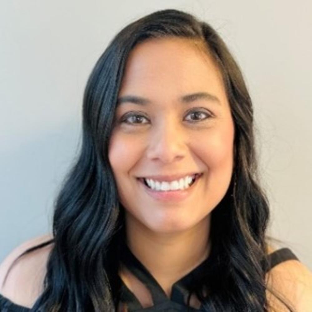 Female employee headshot with tan background