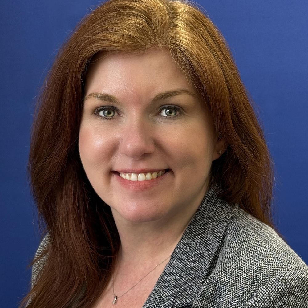 Headshot of female employee on blue background 