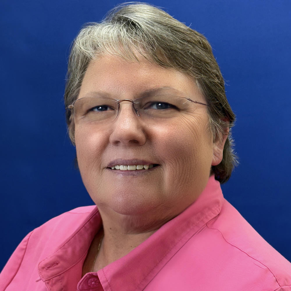 Headshot of female employee on blue background 