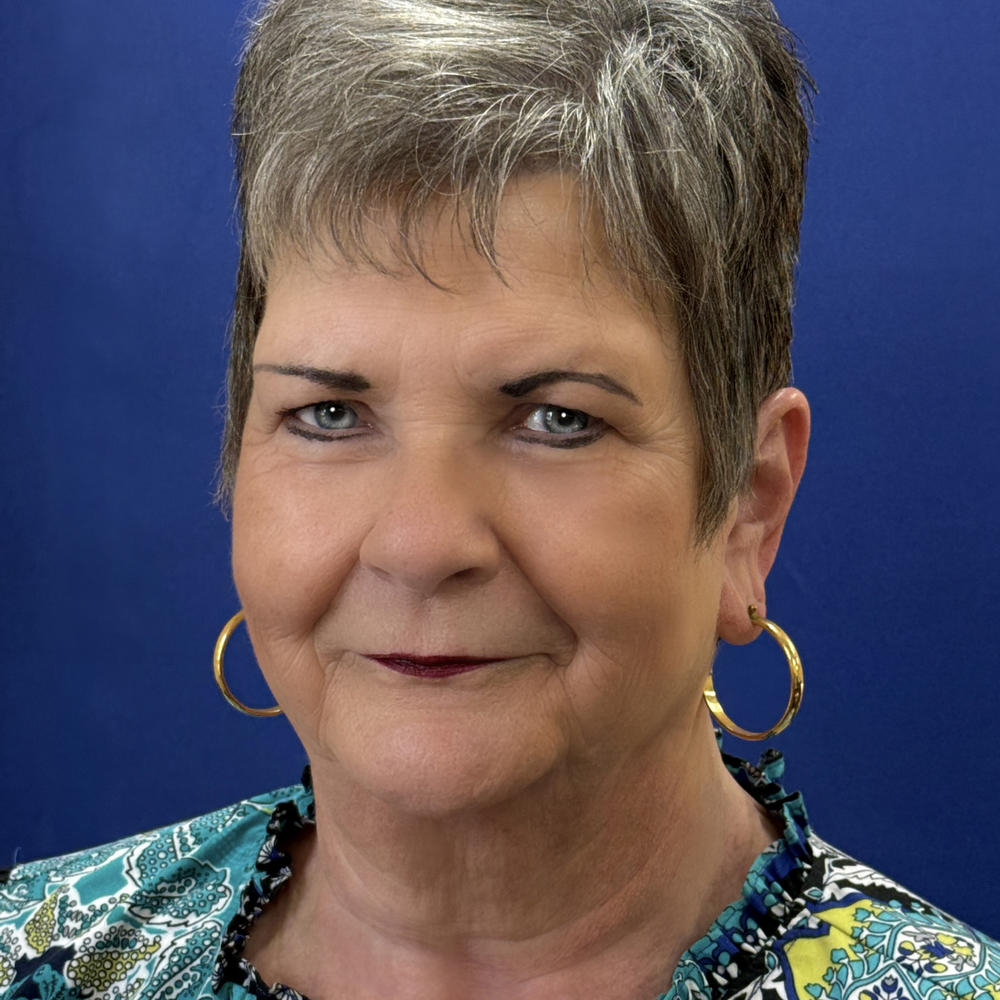 Headshot of female employee on blue background 