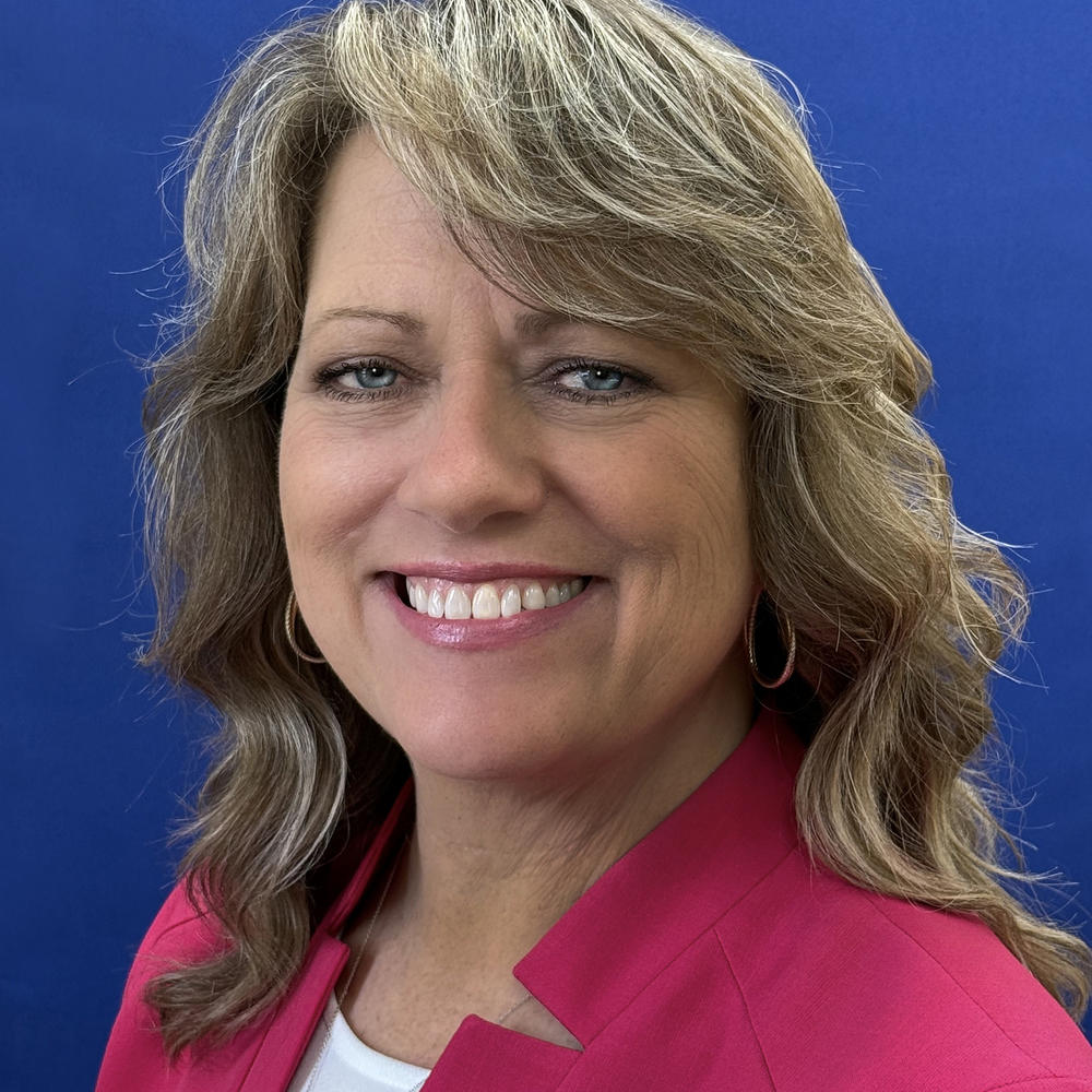 Headshot of female employee on blue background 