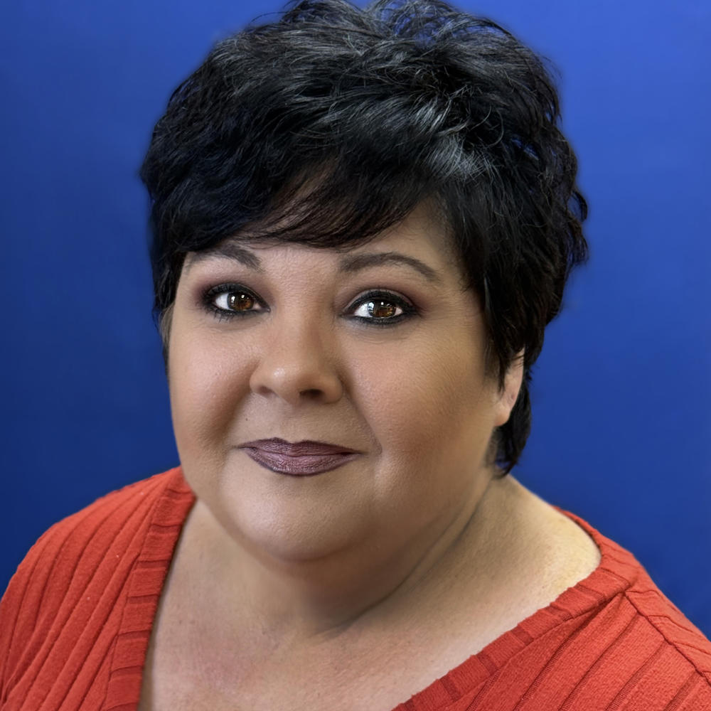 Headshot of female employee on blue background 