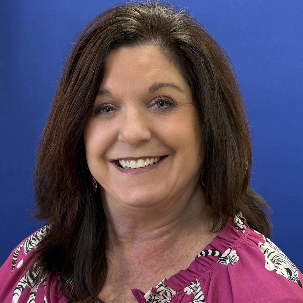 Headshot of female employee on blue background 