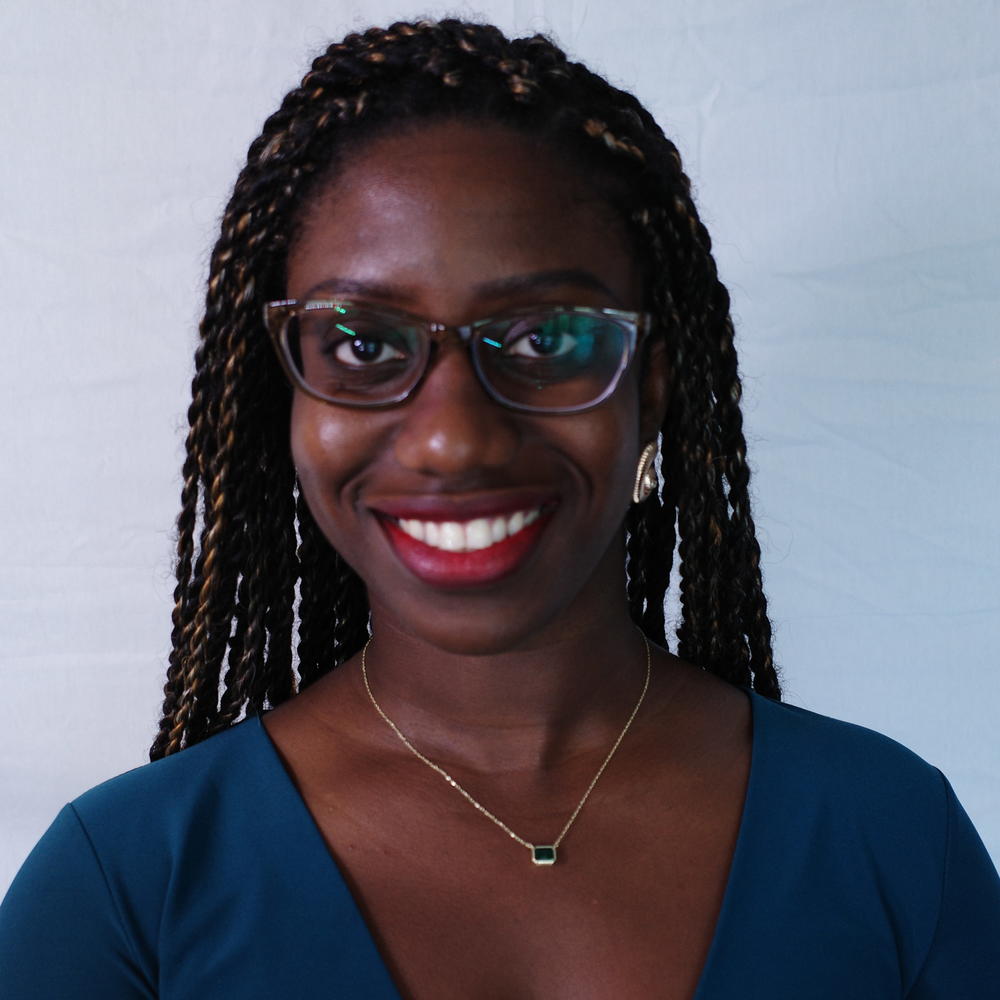 Headshot of female smiling on light gray background 
