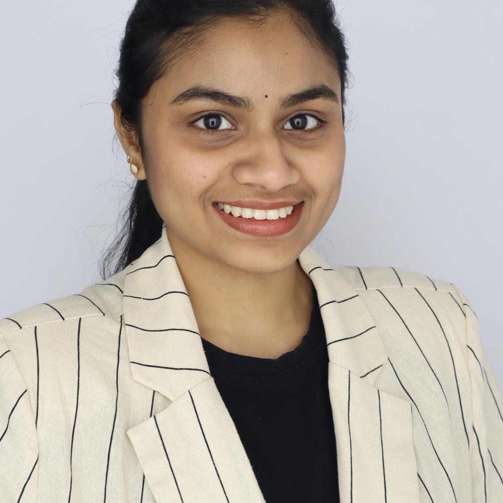 Headshot of female smiling on light gray background