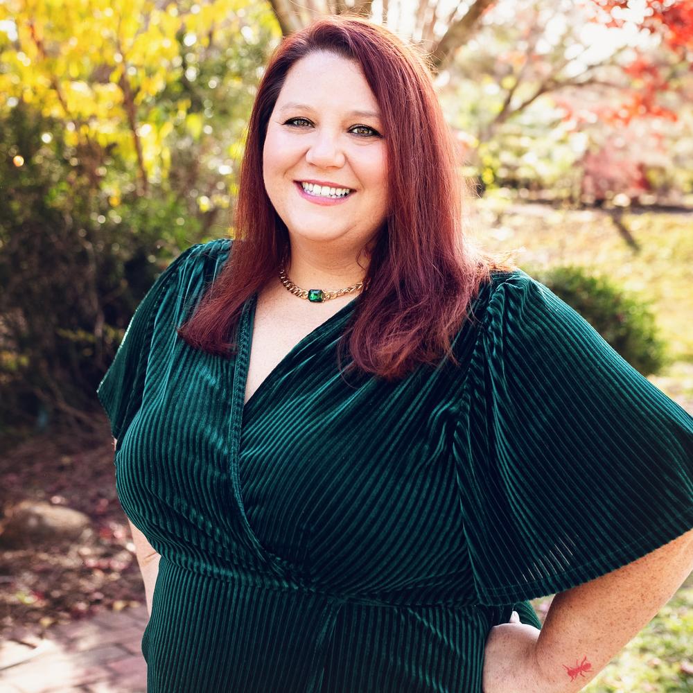 Photo of female in green dress posing outside near trees