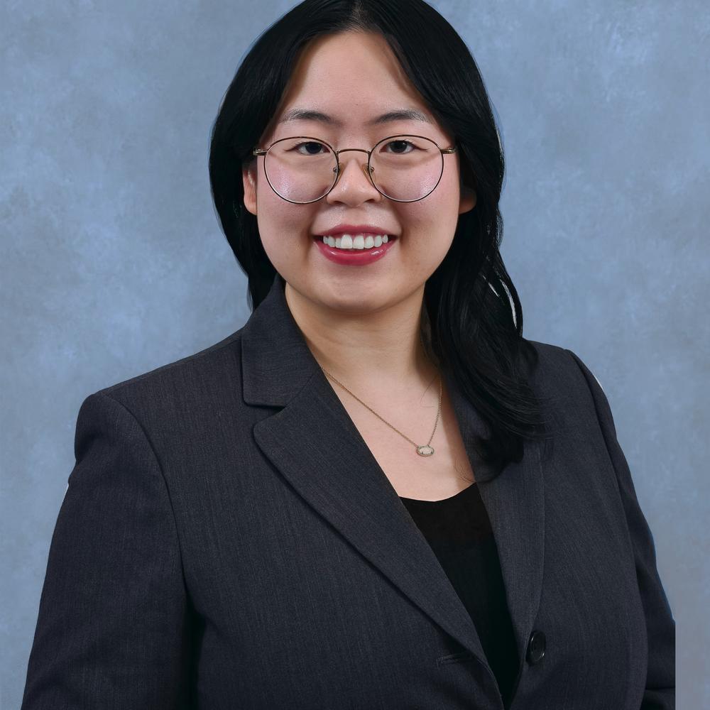 Headshot of female employee smiling on light blue background 