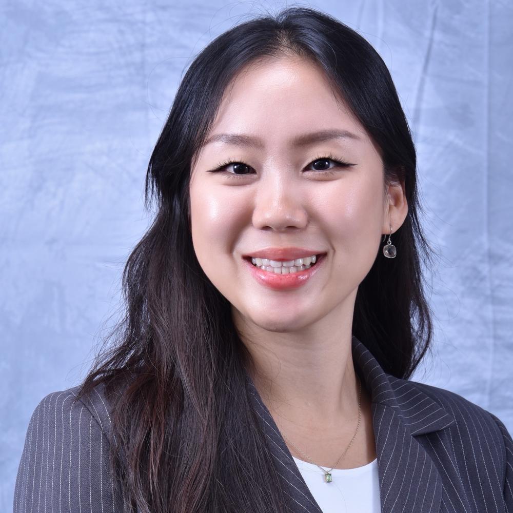 Headshot for female smiling in front of light blue background