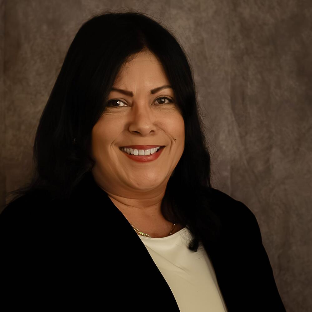 Headshot of female smiling in front of brown background