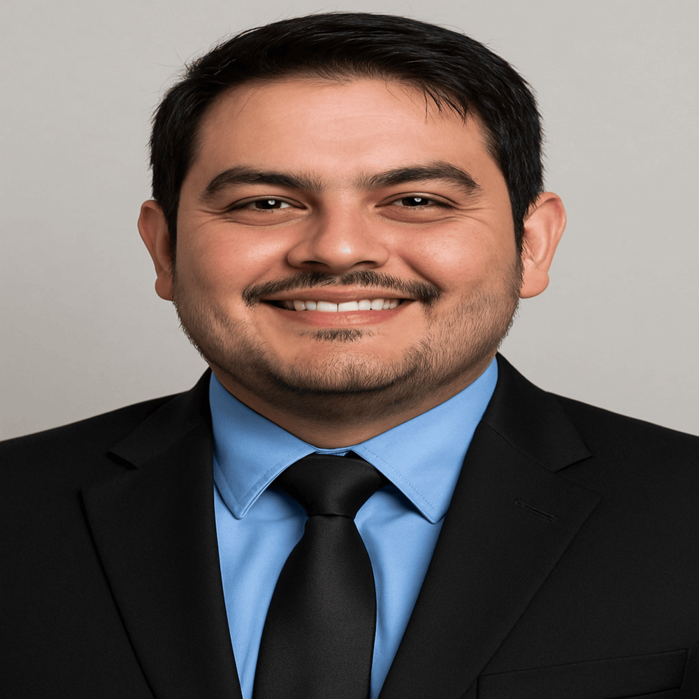 Headshot of male board member smiling in front of light gray background 