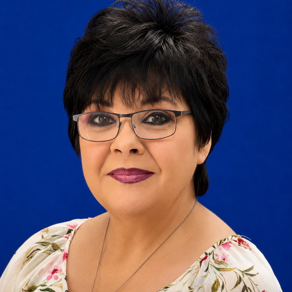 Headshot of female employee smiling in front of blue background 