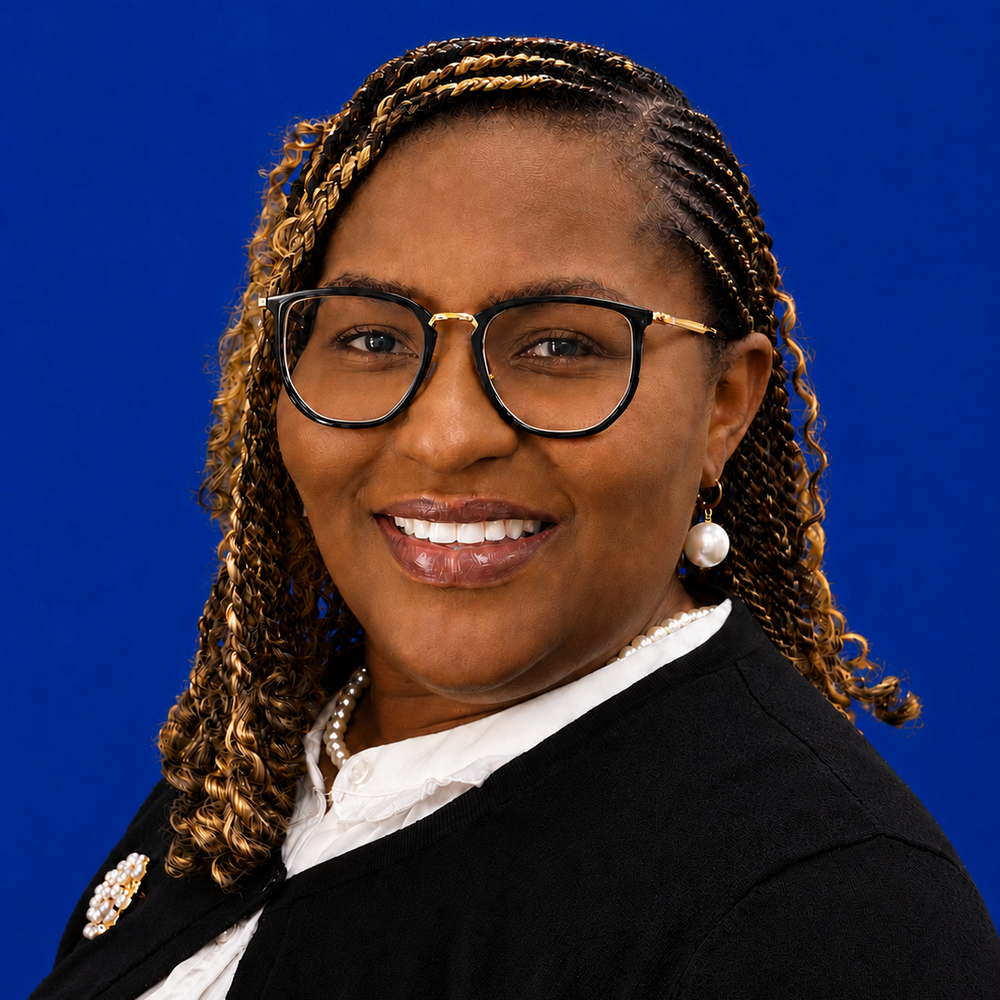 Headshot of female employee smiling in front of blue background 