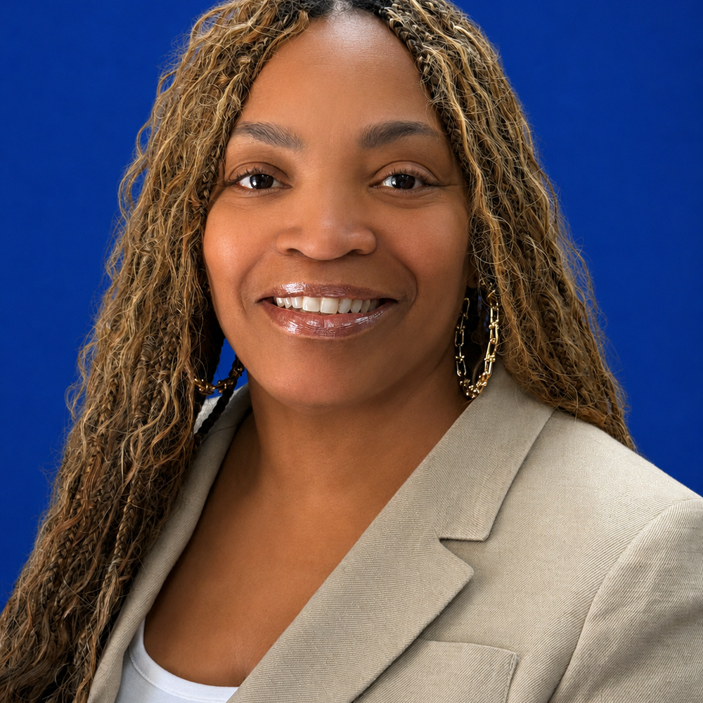 Headshot of female employee smiling in front of blue background 