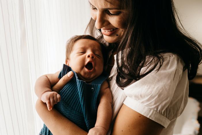 mom smiling at yawning baby