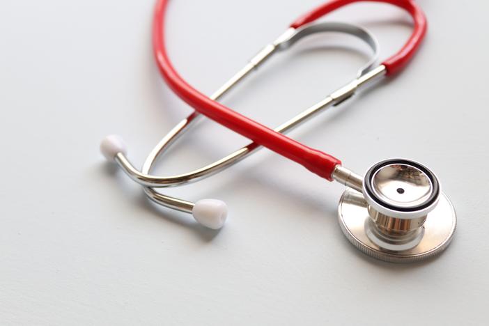 Close-up image of a red stethoscope on a white background.