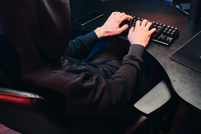 Man in black hoodie on computer.