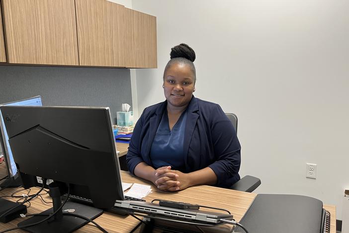 Female employee smiling, sitting at her desk
