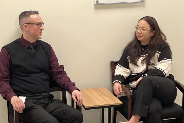 Male and female employee sitting, talking