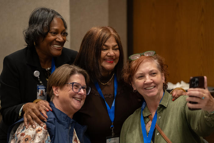 Four female employees smiling, taking a selfie