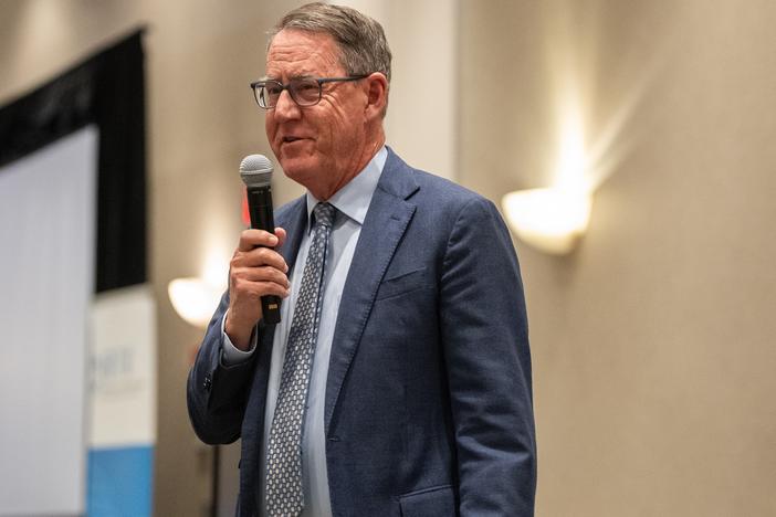 Commissioner speaking on stage with a mic