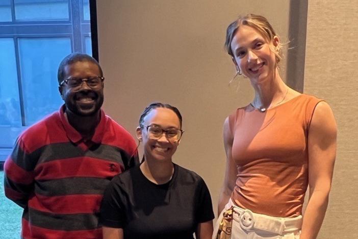 Three employees standing, smiling